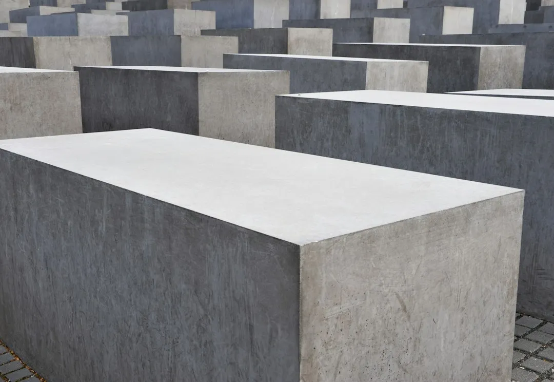 https://images.unsplash.com/photo-1641375863453-238c8b00b867?crop=entropy&cs=tinysrgb&fit=max&fm=jpg&ixid=M3w2NjA1ODR8MHwxfHNlYXJjaHwxNXx8Y29uY3JldGUlMjBibG9ja3N8ZW58MHx8fHwxNzc0OTU3NTM3fDA&ixlib=rb-4.1.0&q=80&w=1080